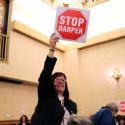 Mary Lou Cherwaty (NTFL President) holds up a "Stop Harper" sign.