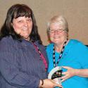 Robyn Benson awarding Irene Berube the Prairie Voice Award for community outreac